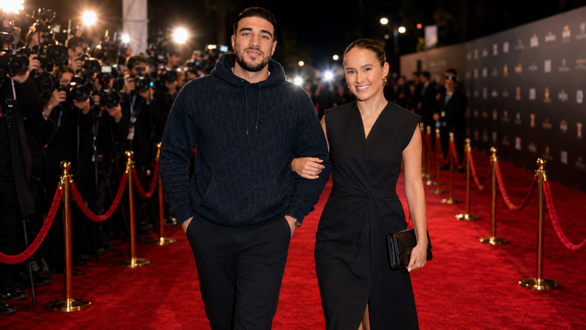 Molly-Mae Hague and Tommy Fury walking together on a glamorous red carpet at an evening event, surrounded by photographers, flashing cameras, and elegant premiere lights.